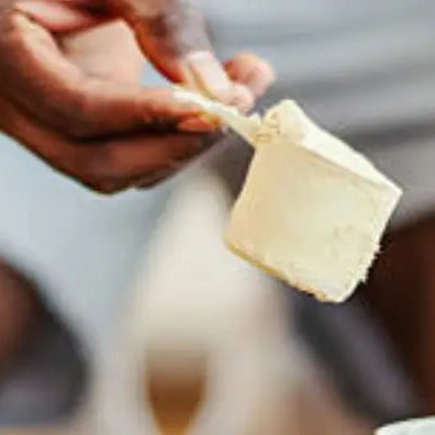 Man scooping creatine at the gym into a bottle image