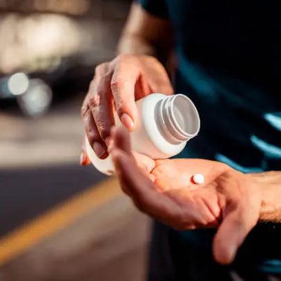 Man dumping supplements in his hand for the gym and workout session
