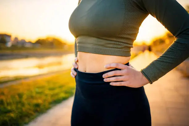 Women showing her gut health after a run outside in the sunrise