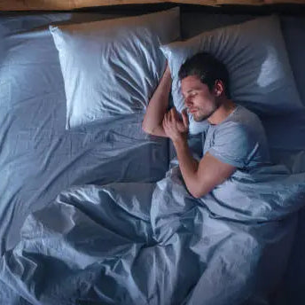 Man sleeping good in his bed getting REM sleep