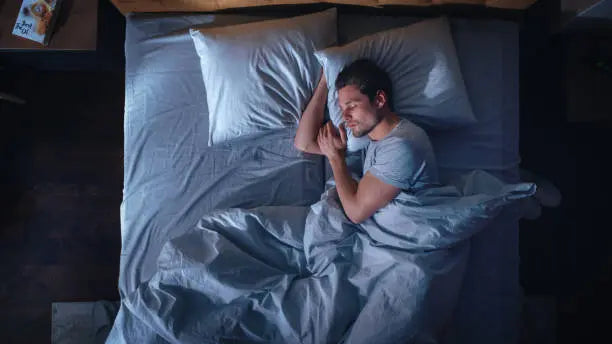 Man sleeping good in his bed getting REM sleep