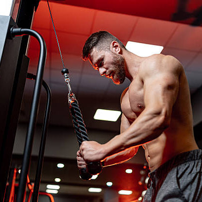 Buff man in a red gym doing an arm workout 